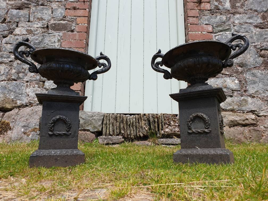 A Pair Of 19Th Century French Small Cast Iron Campagna Urns On Plinths. Circa 1860